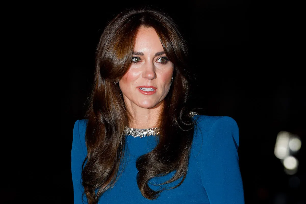 Kate Middleton, who considered not using Princess Diana's Princess of Wales title, looks on wearing a blue dress.