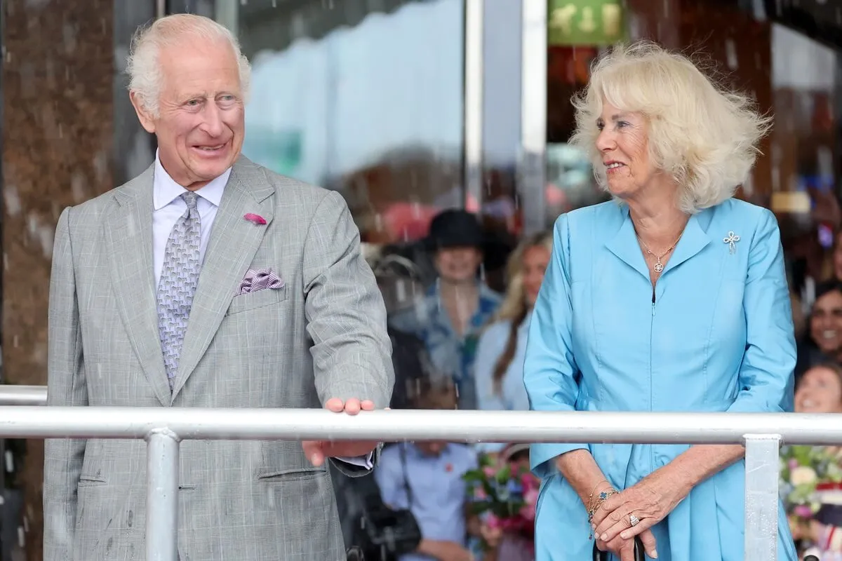 King Charles III and Queen Camilla watch a parade during an official visit to St. Helier, Jersey