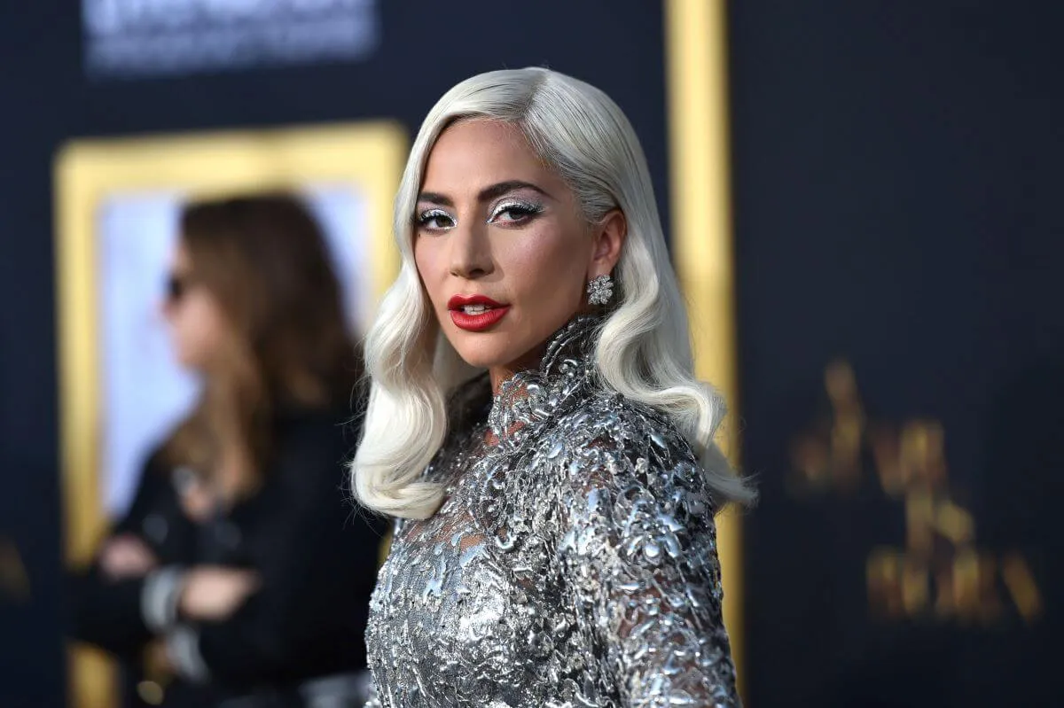 Lady Gaga wears a metallic silver dress and red lipstick.