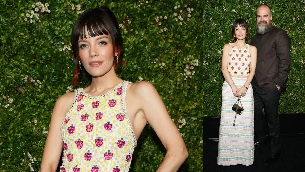Married couple Lily Allen and David Harbor pose together at a Chanel event in front of a floral green wall