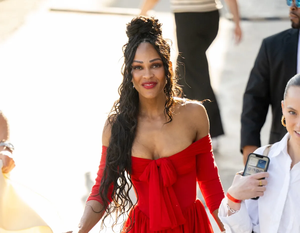 Meagan Good smiles while wearing an off-the-shoulder red minidress