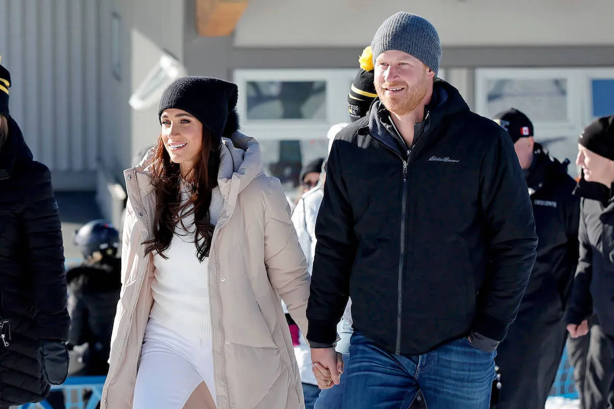 Meghan Markle and Prince Harry hold hands at an Invictus Games event