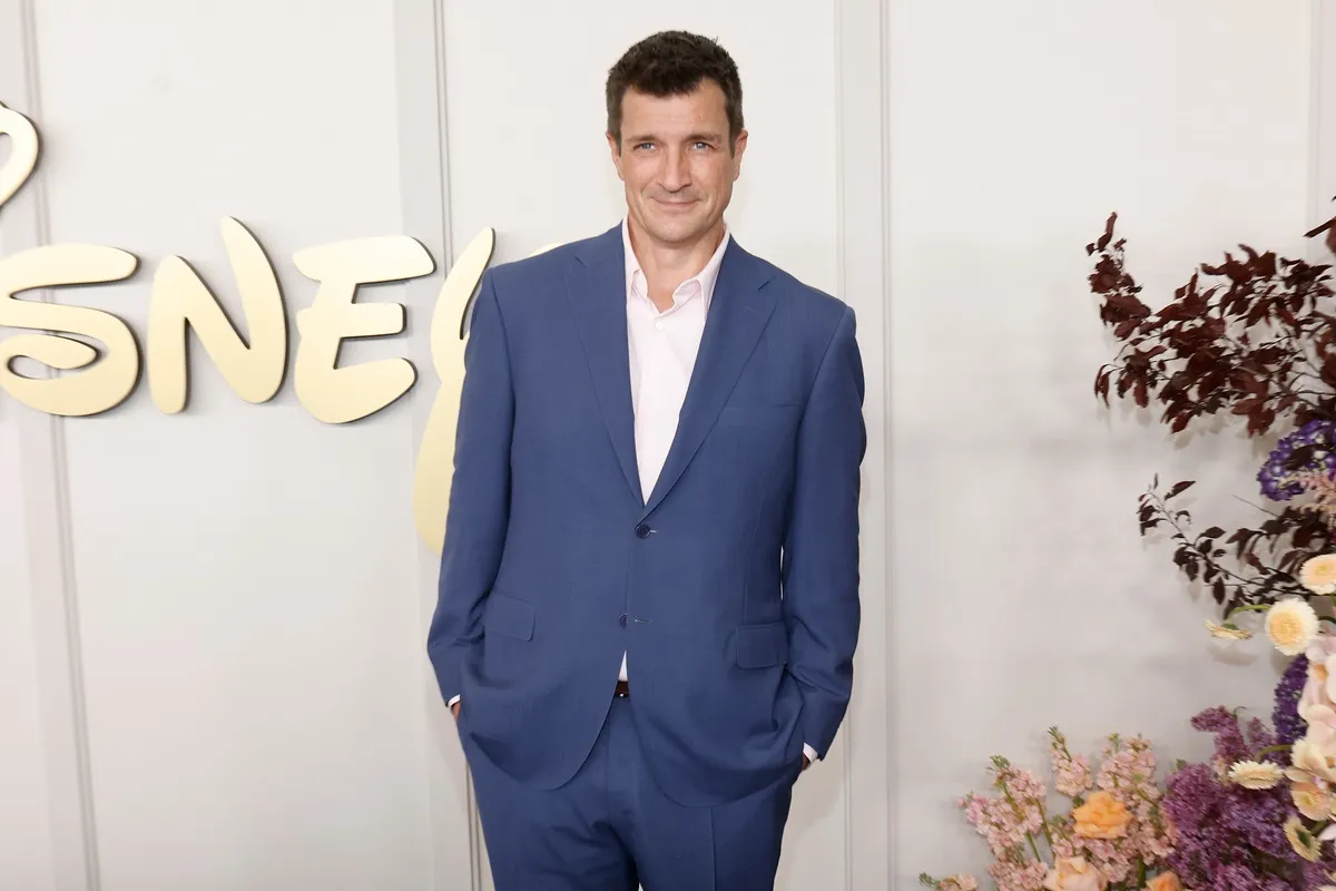 Nathan Fillion posing in a blue suit at the 2024 Disney Upfront at Javits Center.