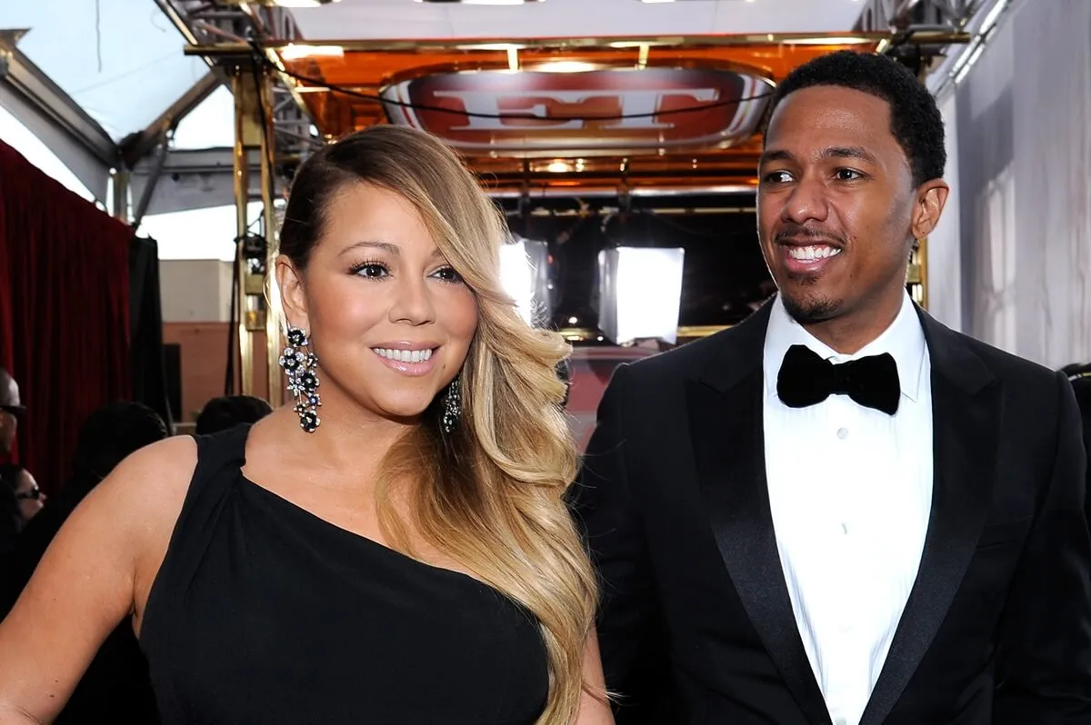 Nick Cannon and Mariah Carey smiling while wearing matching outfits at the 20th Annual Screen Actors Guild Awards.