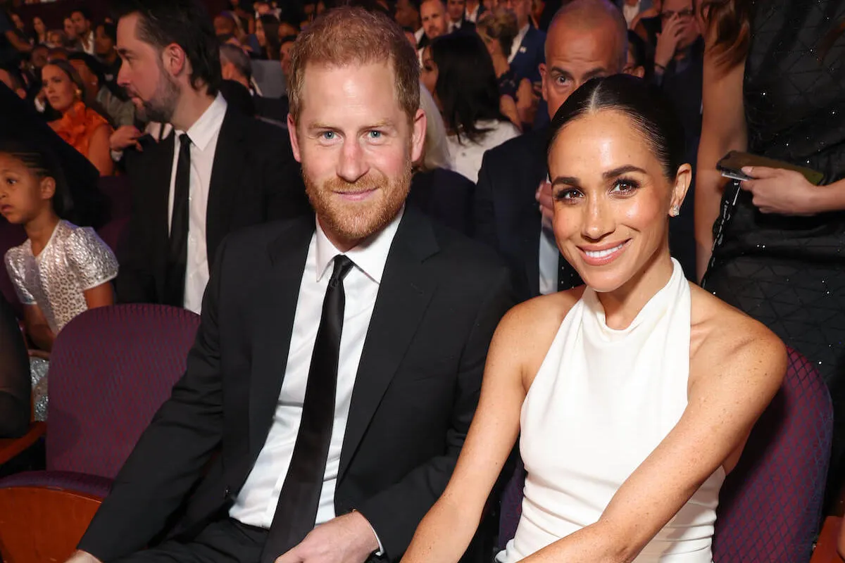 Prince Harry and Meghan Markle, who may go to Balmoral, smile and sit next to each other