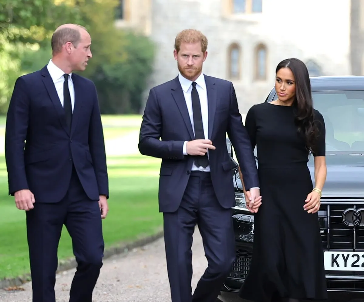 Prince William, Prince Harry, and Meghan Markle on the long Walk at Windsor Castle arrive to view flowers and tributes to Queen Elizabeth II