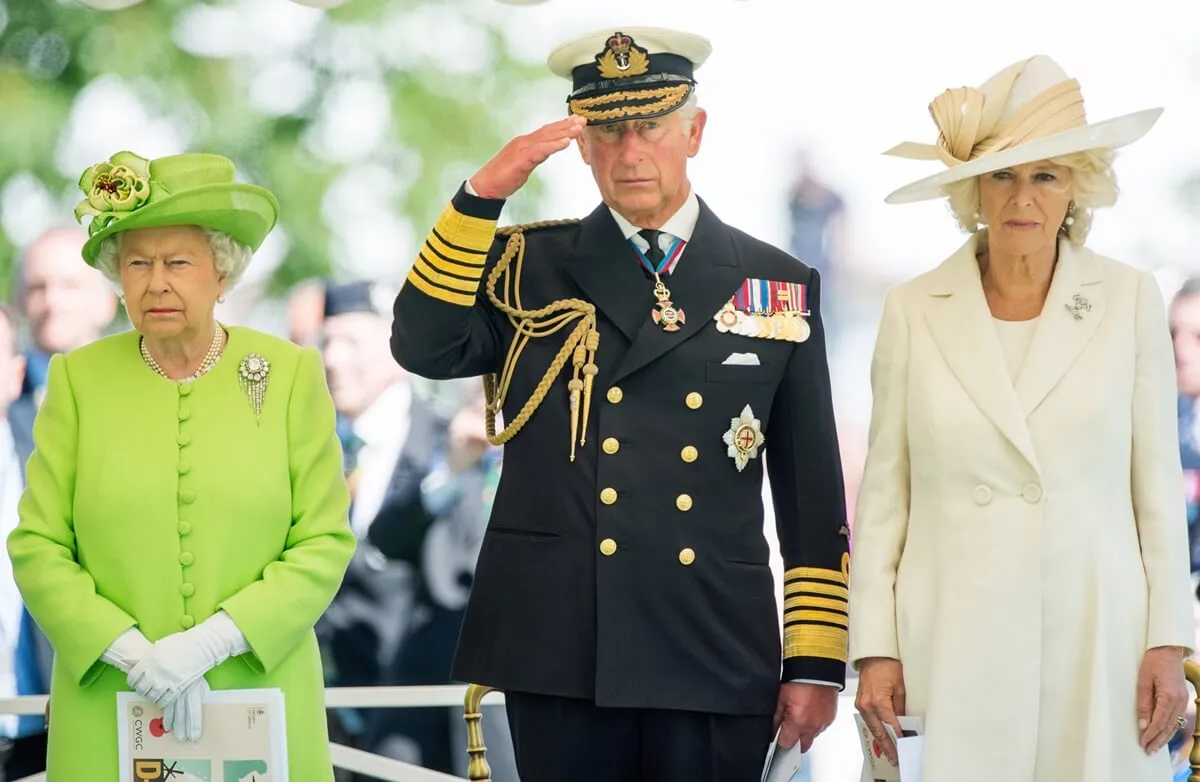 Queen Elizabeth II, then-Prince Charles, and Camilla Parker Bowles attend a service at Bayeux Cemetary in France