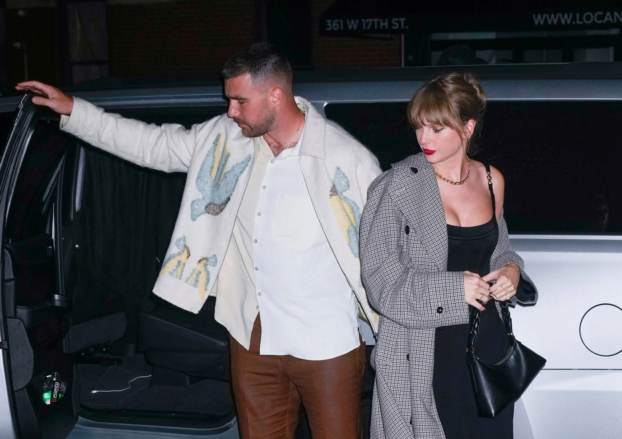 Travis Kelce opening a car door for Taylor Swift at night