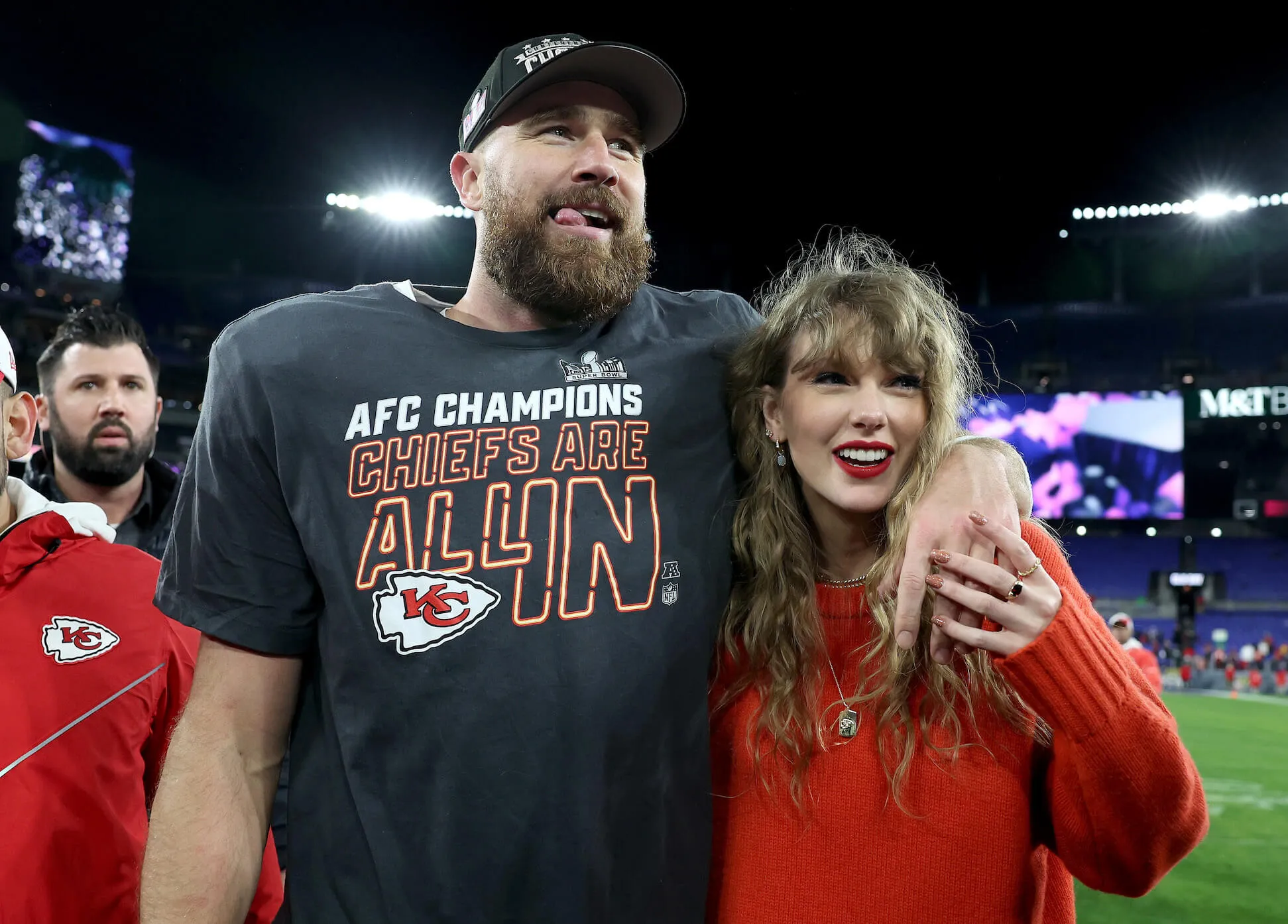 Travis Kelce in his Kansas City Chiefs uniform with his arm around Taylor Swift, who's smiling. They celebrate Kelce's NFL victory against the Baltimore Ravens.