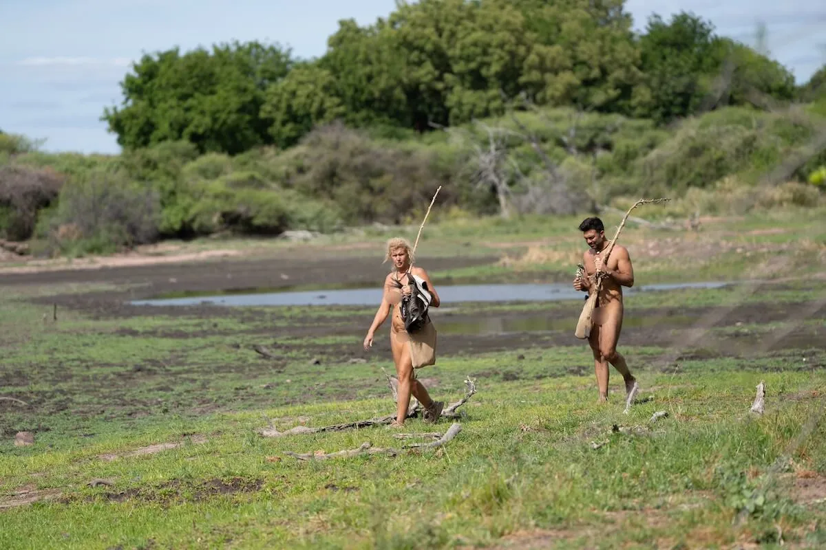 Trish and Fernando walking on a savanna in 'Naked and Afraid: Last One Standing' Season 2