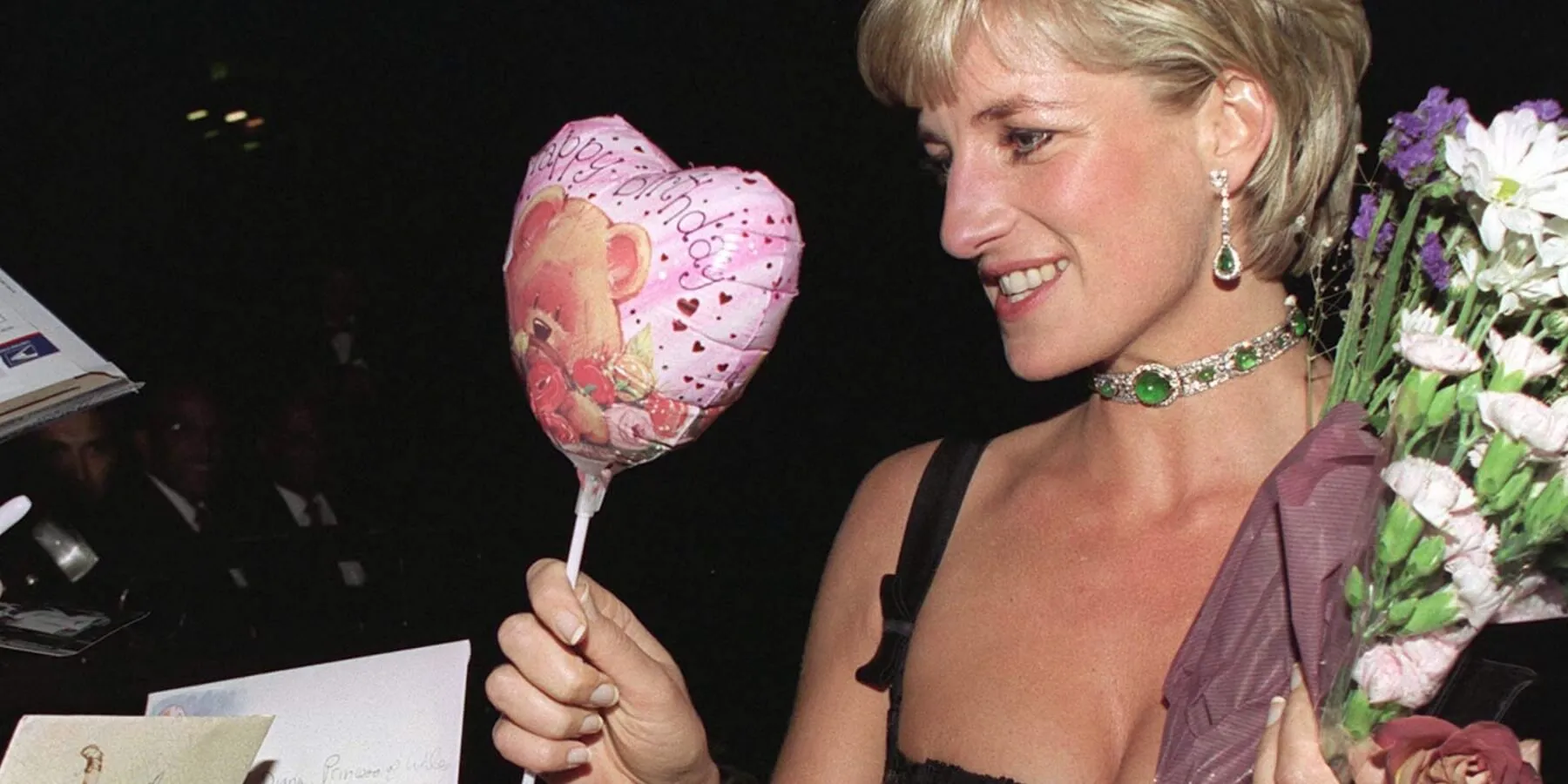 Princess Diana holds a pink heart balloon as she meets with fans