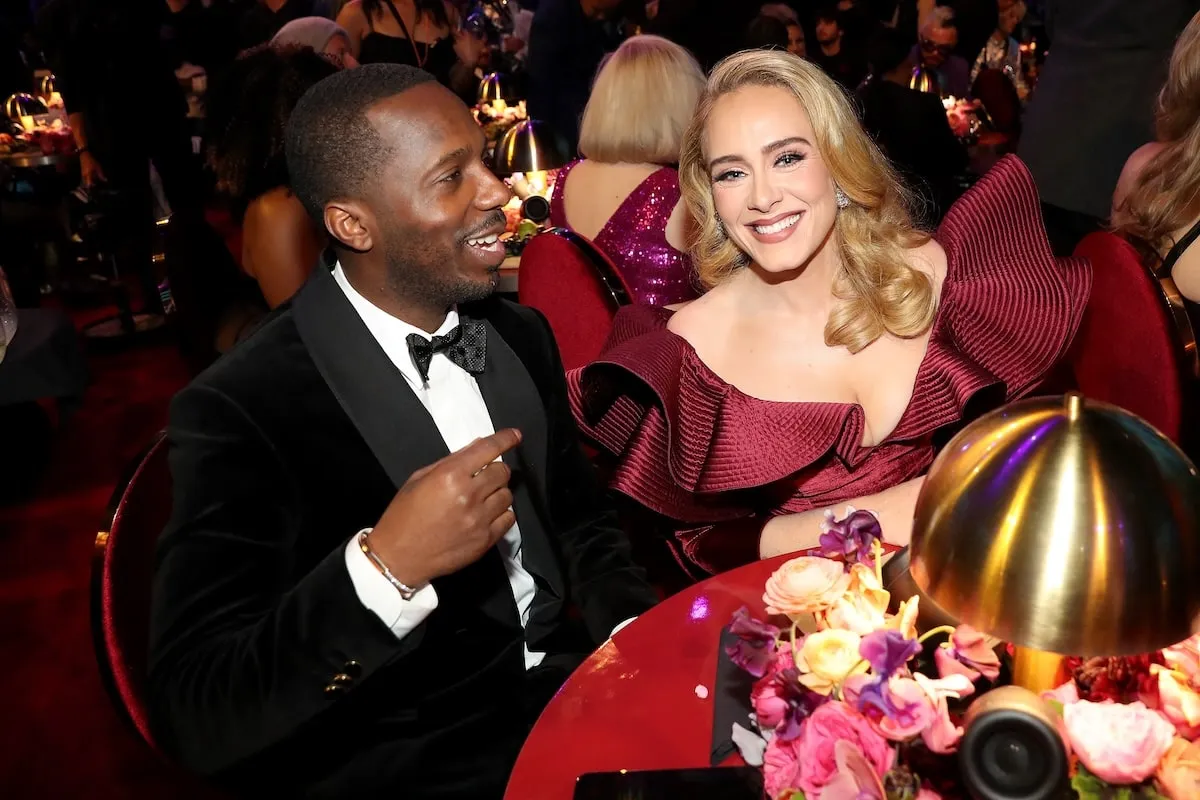 Wearing formalwear, Rich Paul and Adele pose for a photo while sitting at their table at the 2023 Grammy Awards