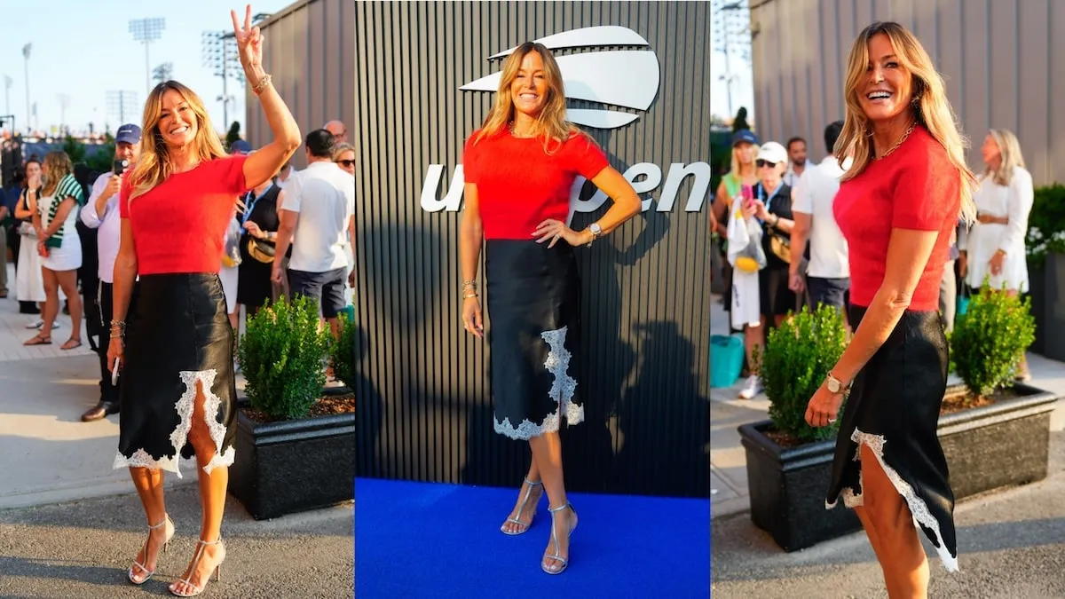 Wearing a red tee and black skirt, Kelly Bensimon waves to fans at the 2024 US Open Tennis Championships