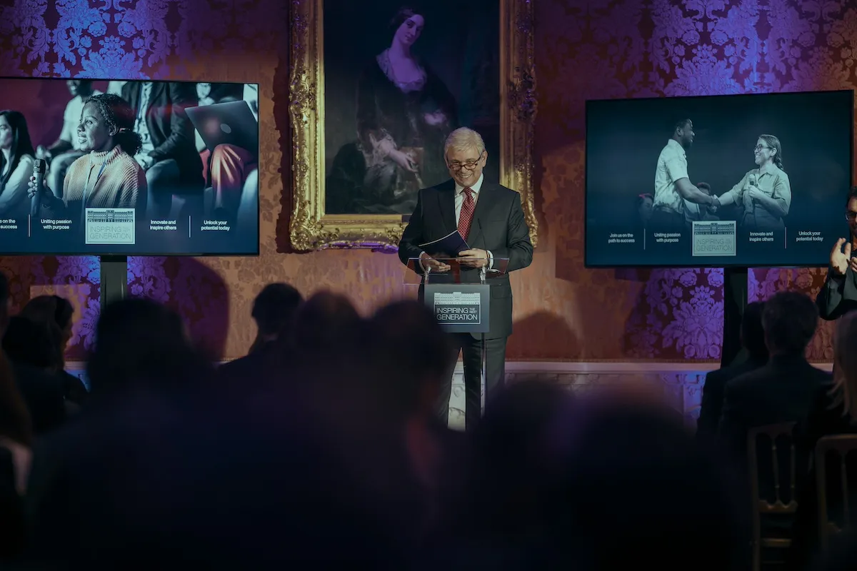 Michael Sheen as Prince Andrew giving a talk at an event