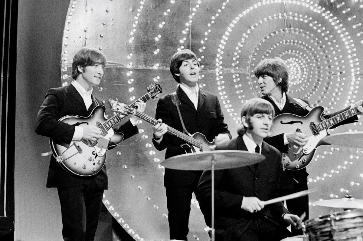 A black and white picture of The Beatles performing together.