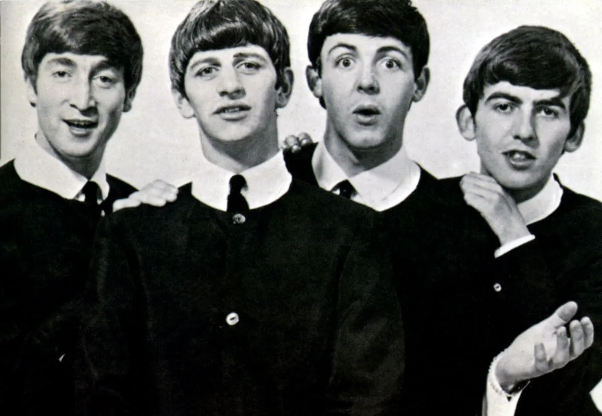 A black and white picture of John Lennon, Ringo Starr, Paul McCartney, and George Harrison of The Beatles wearing matching outfits.