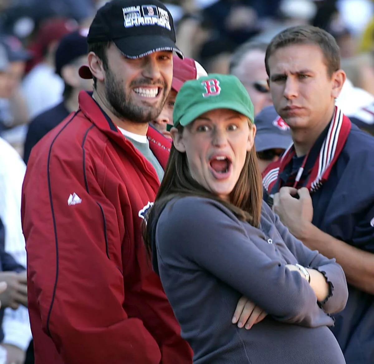 Ben Affleck and Jennifer Garner wear baseball hats and watch a baseball game. Garner is pregnant.