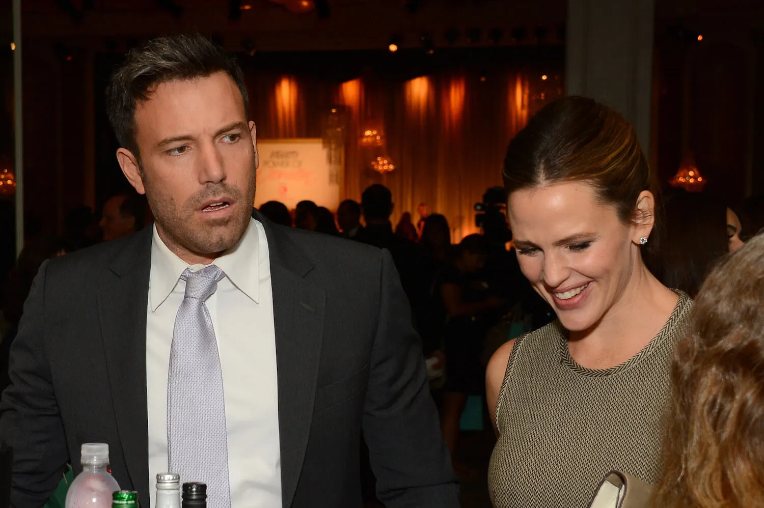 Ben Affleck looks concerned while Jennifer Garner stands beside him and looks down and smiles at an event in 2012