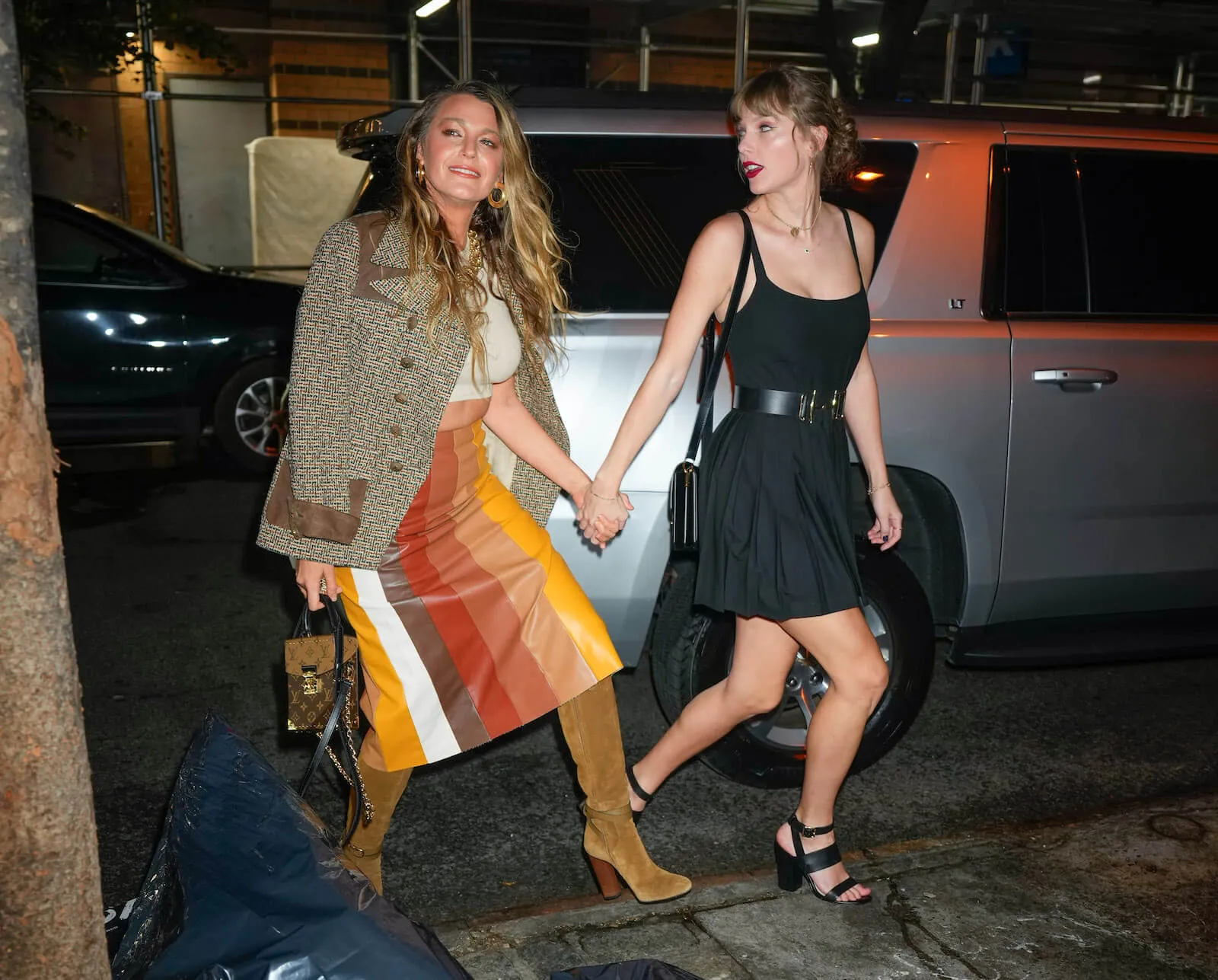 Blake Lively and Taylor Swift holding hands while walking in New York City at night in 2023