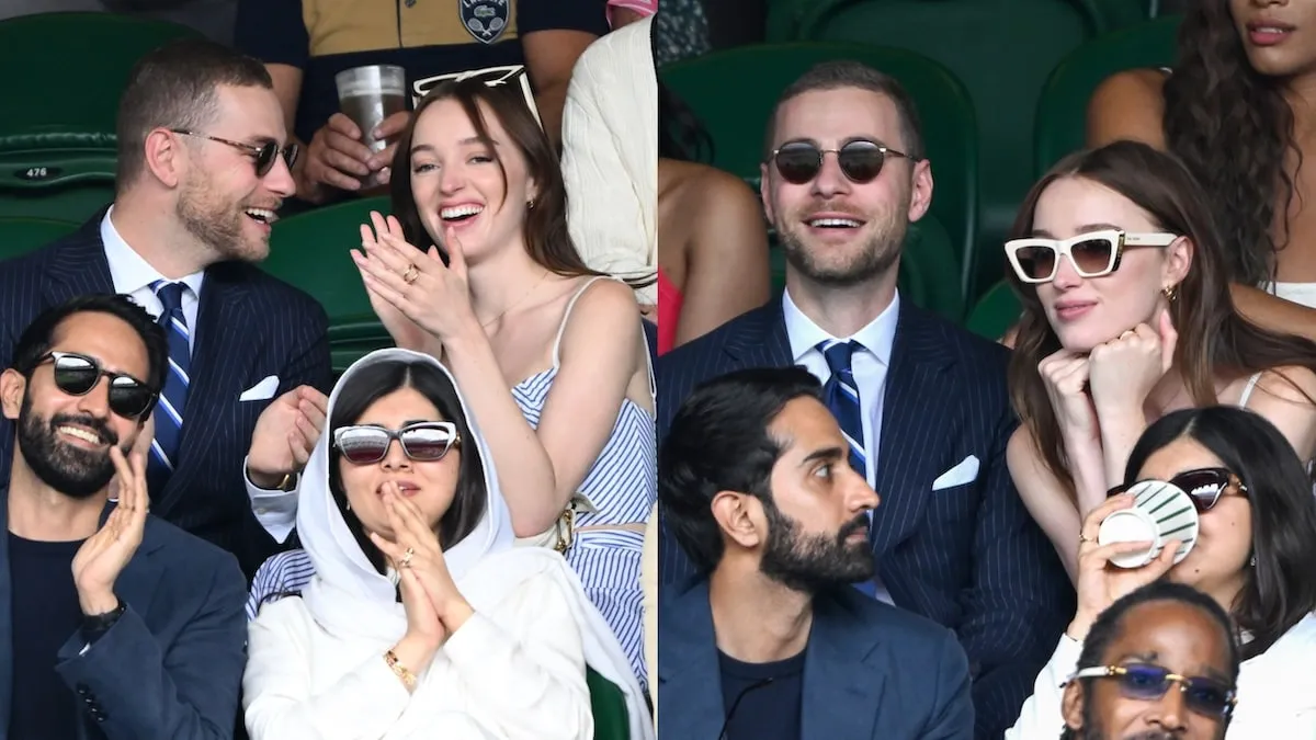 Cameron Fuller and Phoebe Dynevor sit together and laugh in the stands during day seven of the Wimbledon Tennis Championships