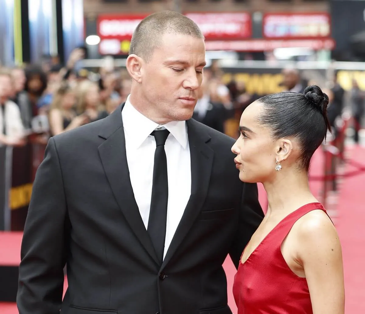 Channing Tatum and Zoe Kravitz look at each other on the red carpet at the premiere of 'Blink Twice.' He wears a suit and she wears a red dress.