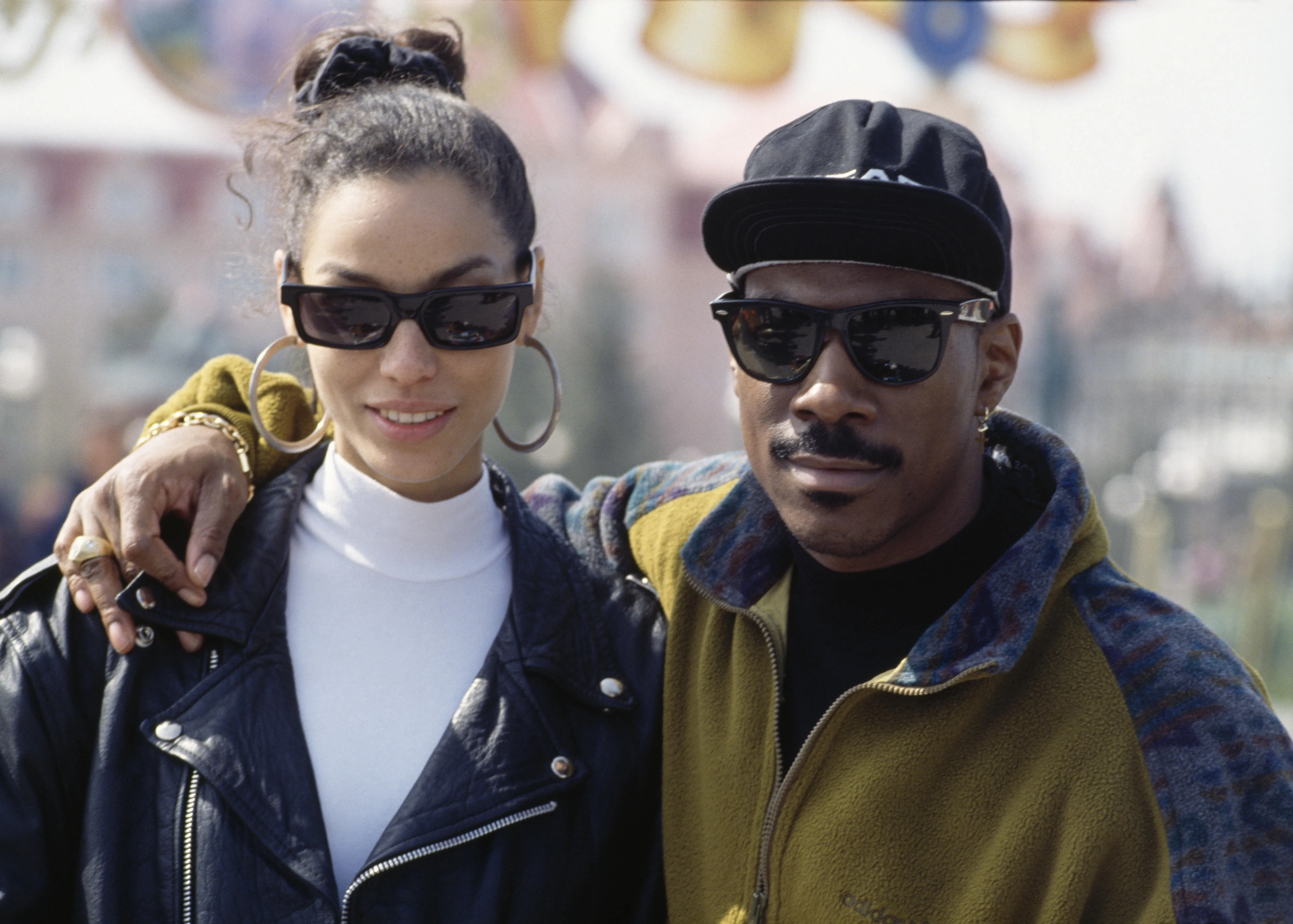 Comedian Eddie Murphy poses for a photo with his arm around his girlfriend Nicole Murphy's shoulder