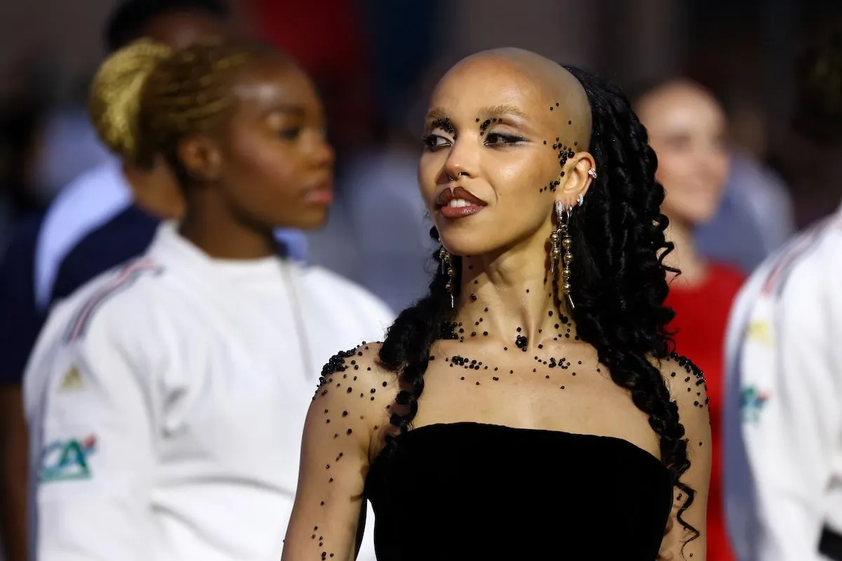 Singer FKA twigs wears a black dress and black gemstones on her skin during a Vogue event in Paris