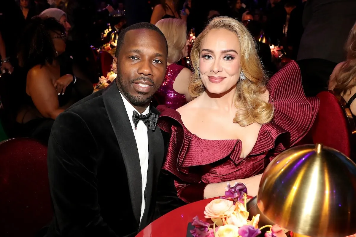 Wearing formalwear, Rich Paul and Adele pose for a photo while sitting at their table at the 2023 Grammy Awards