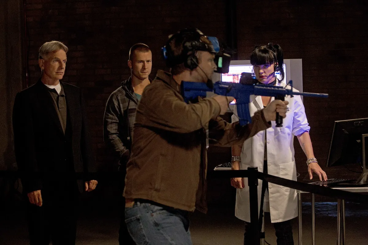 A man shoots a gun while Gibbs and Abby look on in 'NCIS'