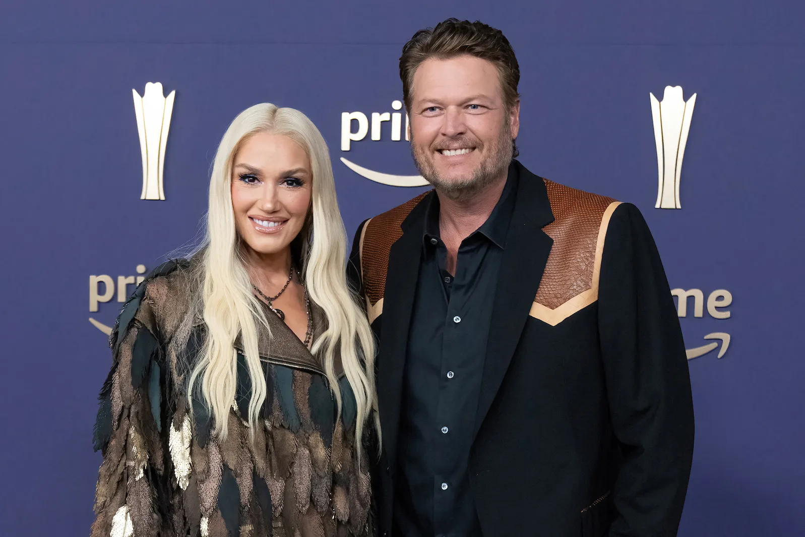 Gwen Stefani and Blake Shelton posing and smiling after they arrived for the 59th Academy of Country Music awards