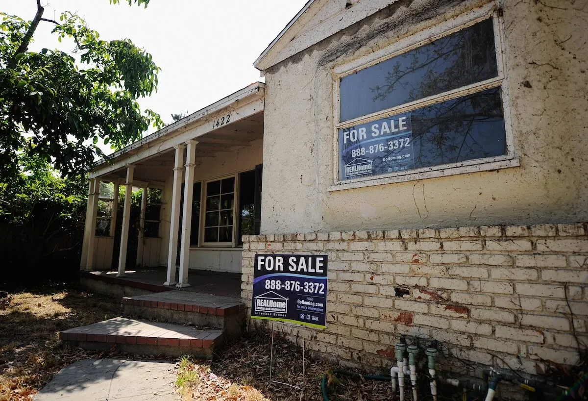 Decrepit home with for sale sign out front