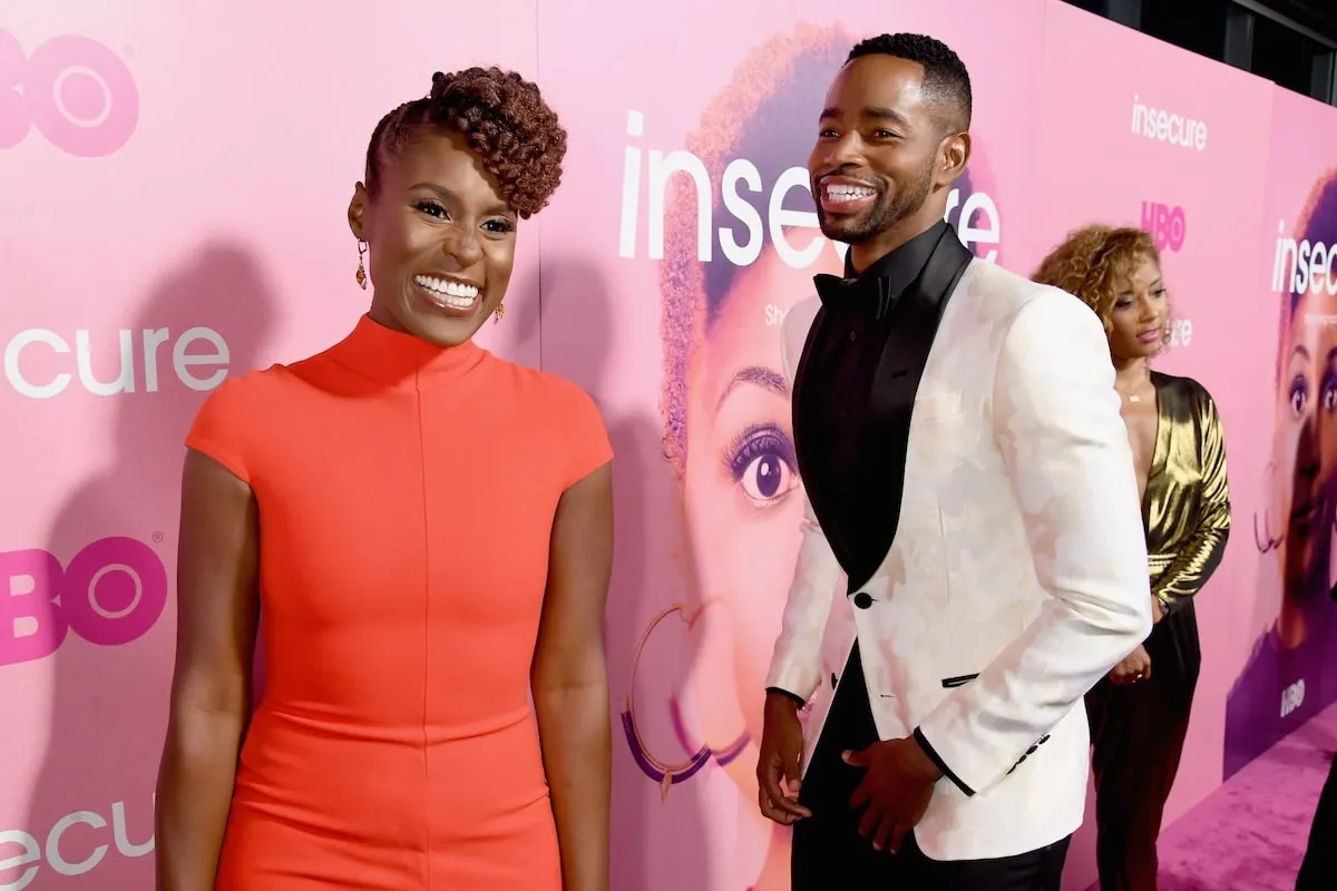 Insecure stars Issa Rae and Jay Ellis laugh together on a red carpet in 2016