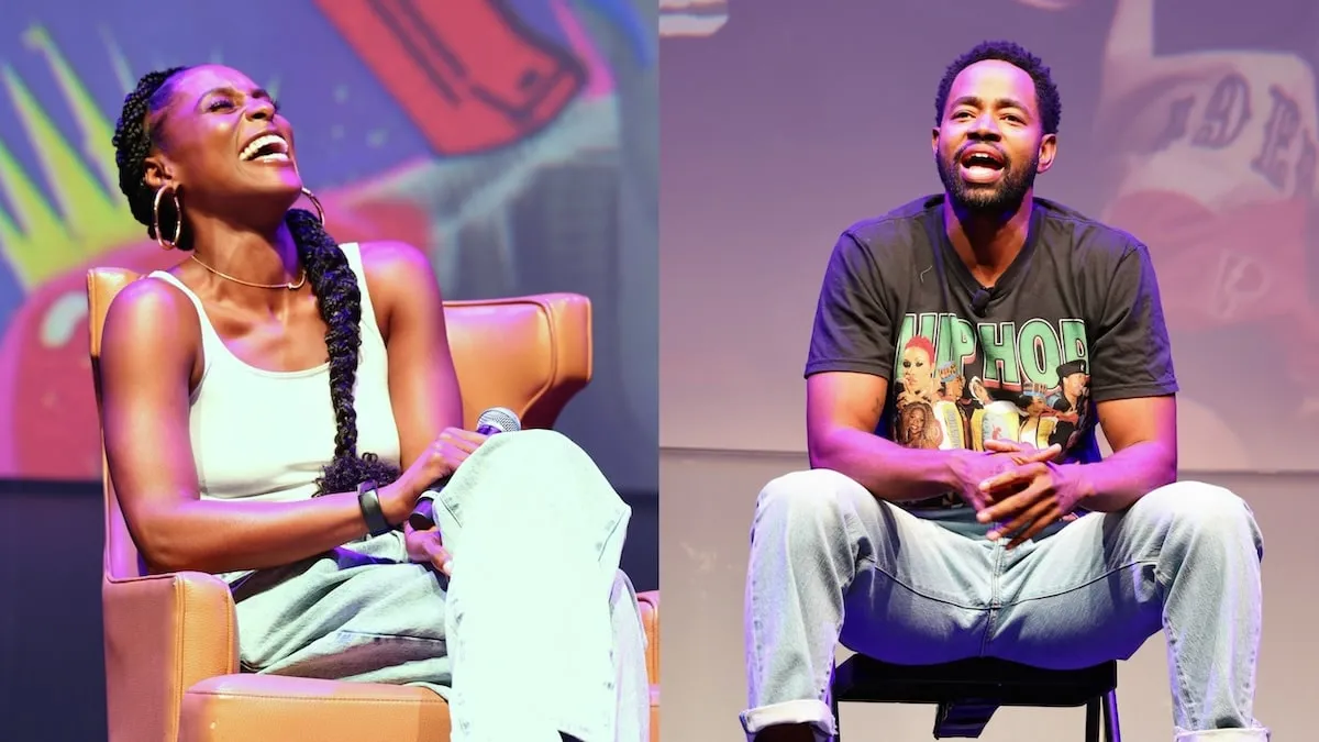 Actors Issa Rae and Jay Ellis laugh together on stage at his book release event