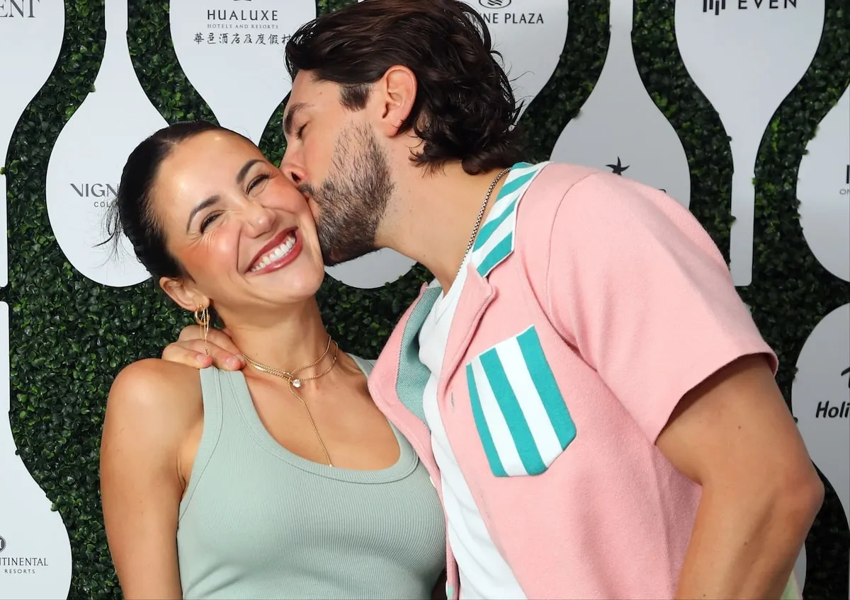 Reality star Jason Tartick kisses influencer Kat Stickler on the cheek at the U.S. Open