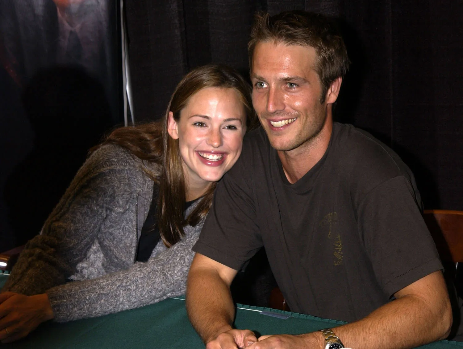 Jennifer Garner holding on to Michael Vartan's arm while smiling