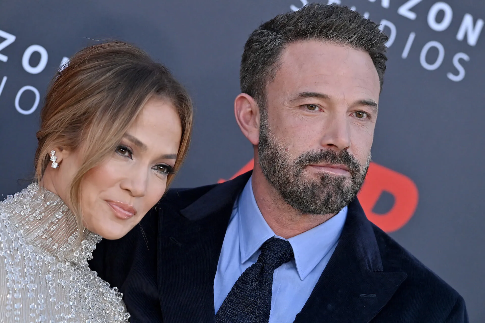 A close-up of Jennifer Lopez and Ben Affleck softly smiling at a movie premiere in March 2023