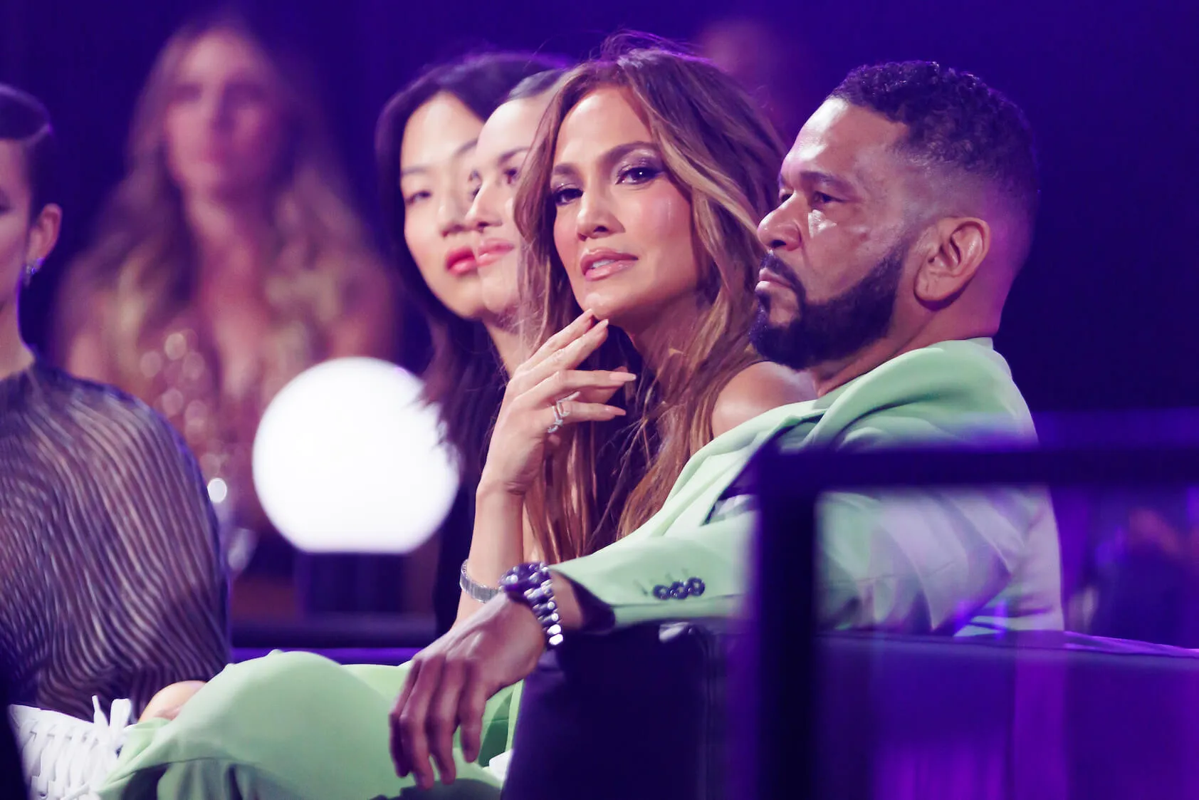 Jennifer Lopez sitting next to Benny Medina and looking past him at the 2022 MTV Movie & TV Awards