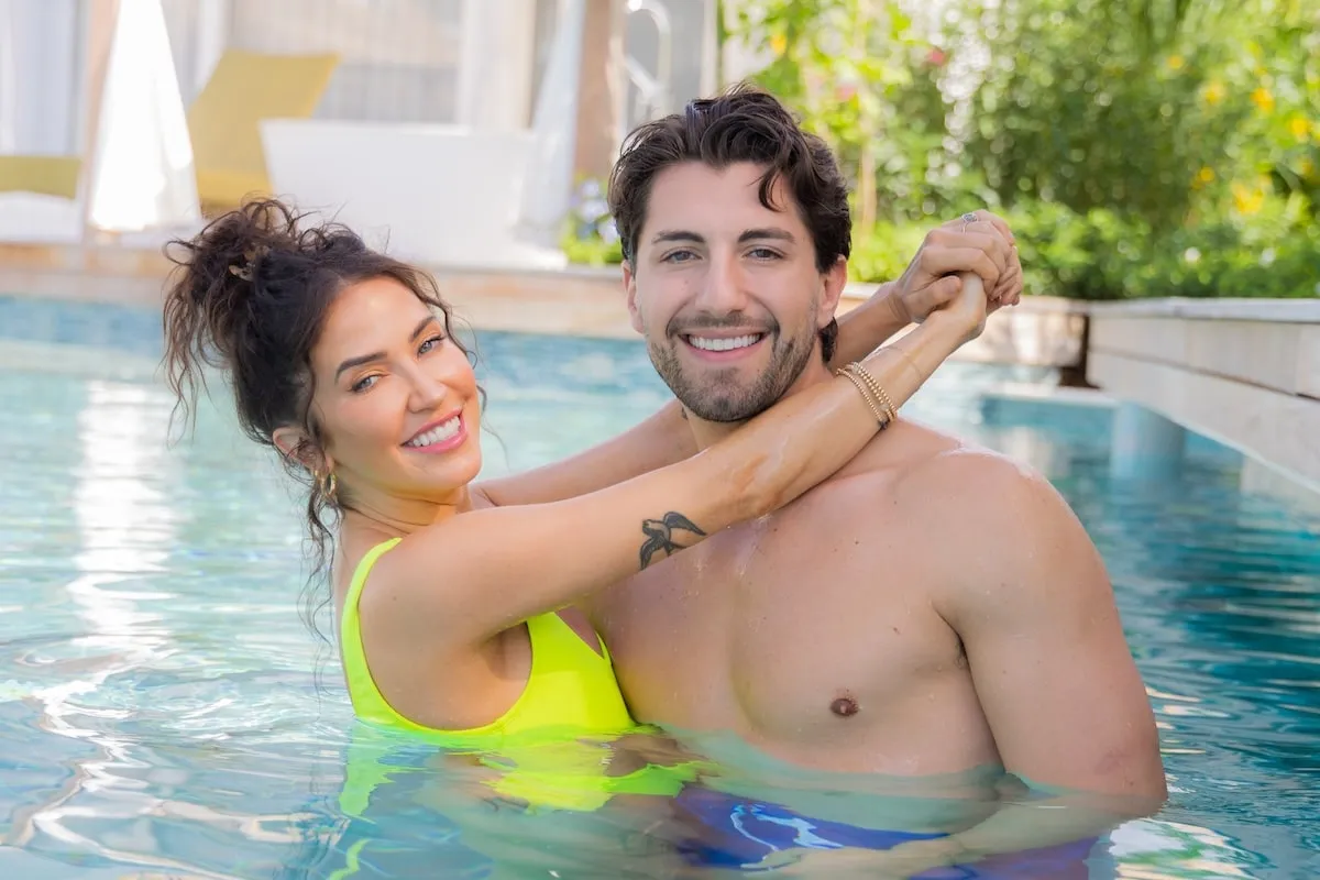 Then-couple Kaitlyn Bristowe and Jason Tartick hug in a pool