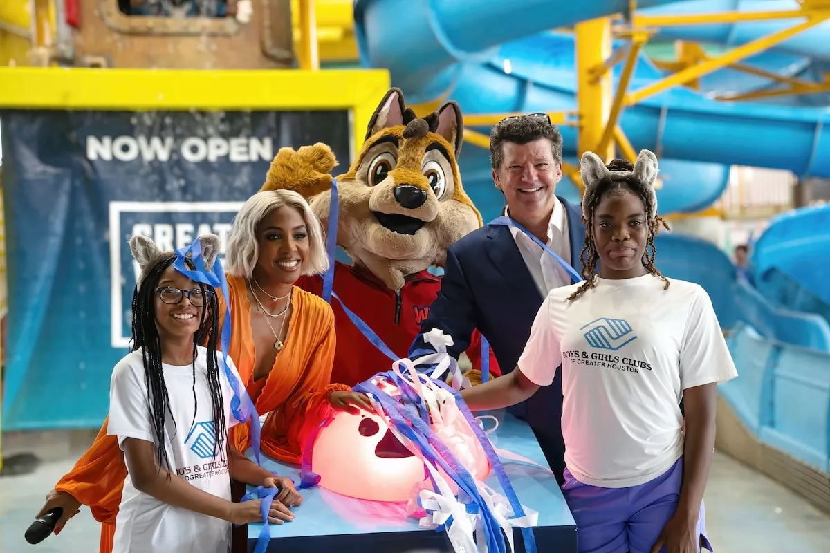 Singer Kelly Rowland poses for a photo with the CEO of Great Wolf Lodge and some members of Boys & Girls Club