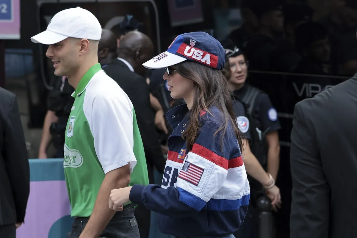 Fai Khadra in a green polo and Kendall Jenner in red white and blue walks to their seats to watch the U.S. women's gymnastics team at the 2024 Summer Olympics