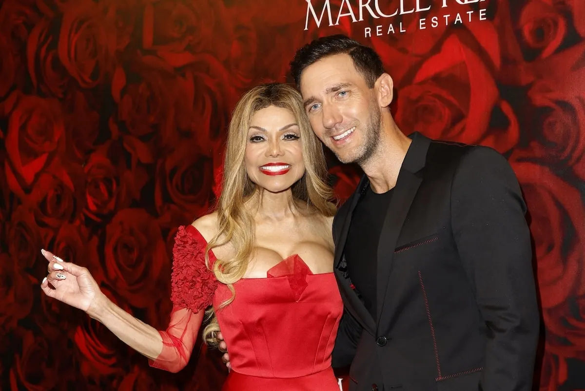 Wearing a red dress, La Toya Jackson smiles with a party-goer in Mallorca, Spain