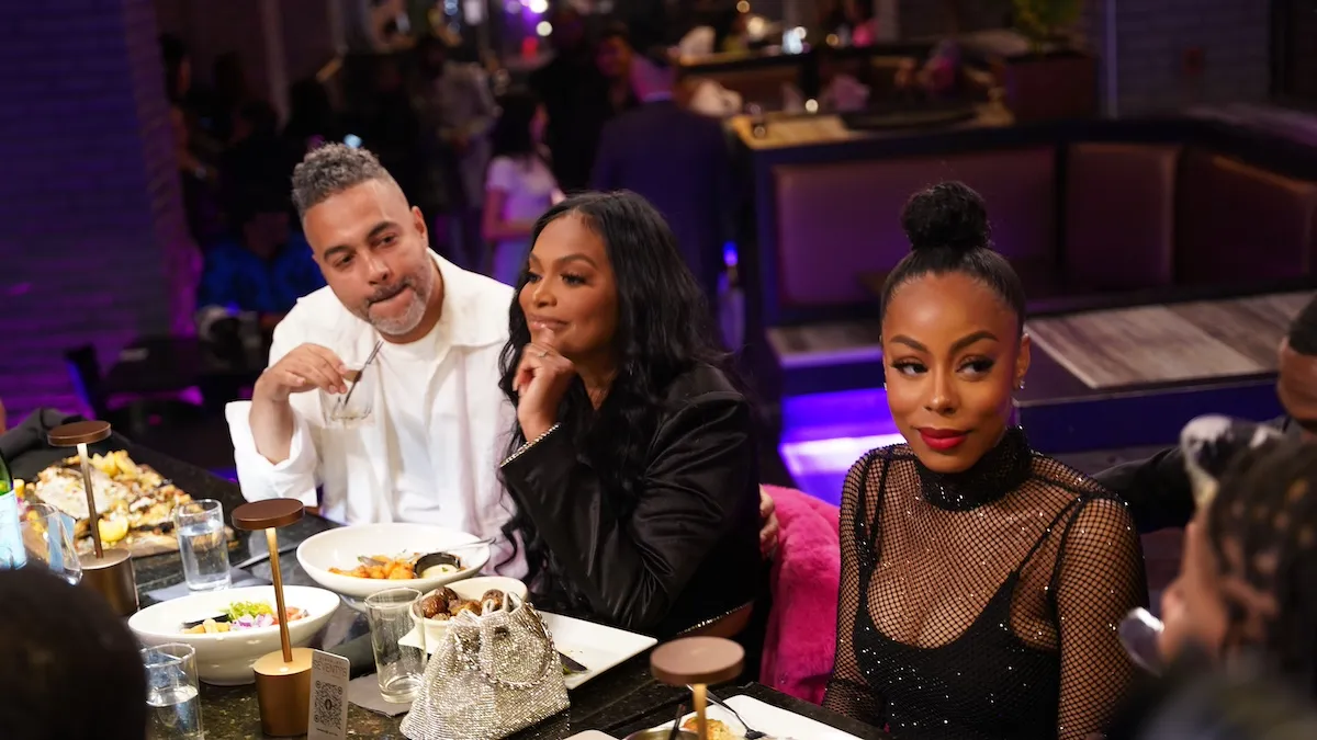 Three people sitting at a table in a restaurant in 'Love & Marriage: Detroit' Season 2