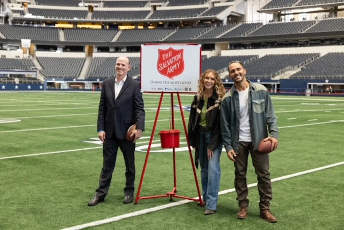 Alexa and Carlos PenaVega pose with a Salvation Army kettle at AT&T stadium