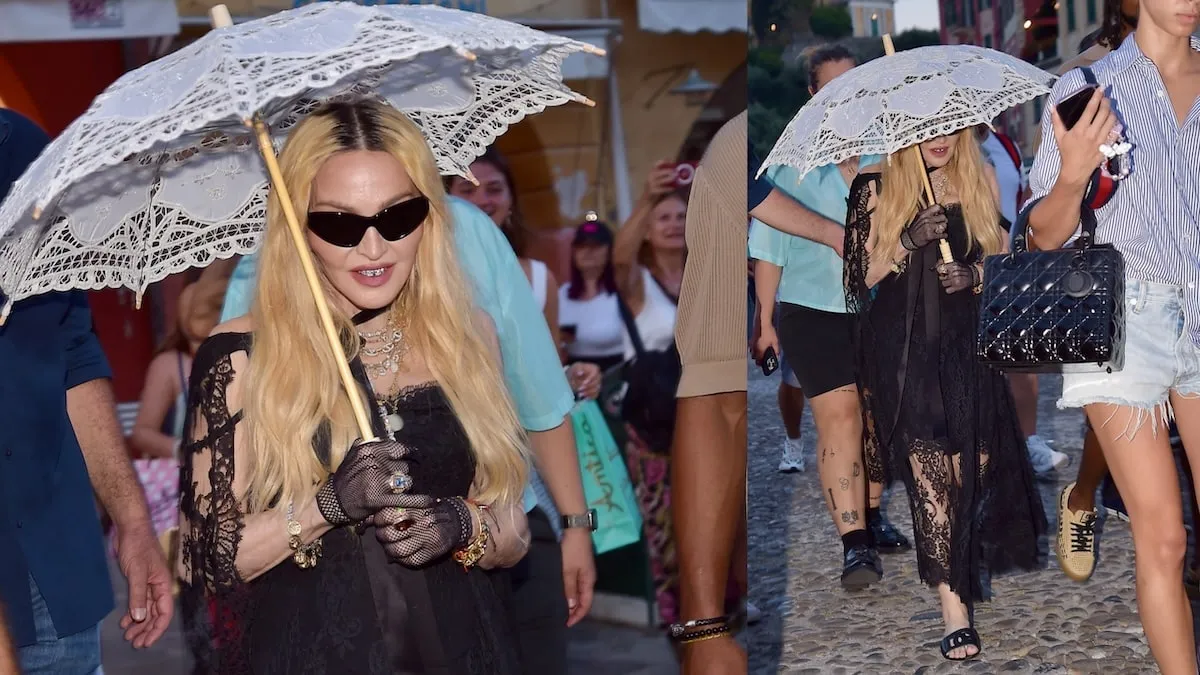 Wearing a black dress and carrying a white lacy umbrella, Madonna walks through Portofino, Italy, with her boyfriend Akeem Morris