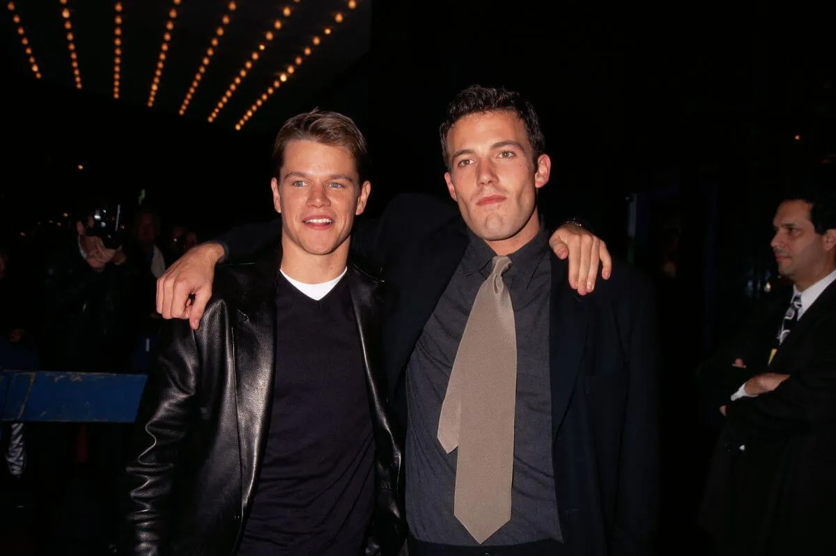 Matt Damon and Ben Affleck stand with their arms around each other at the premiere of 'Good Will Hunting.'