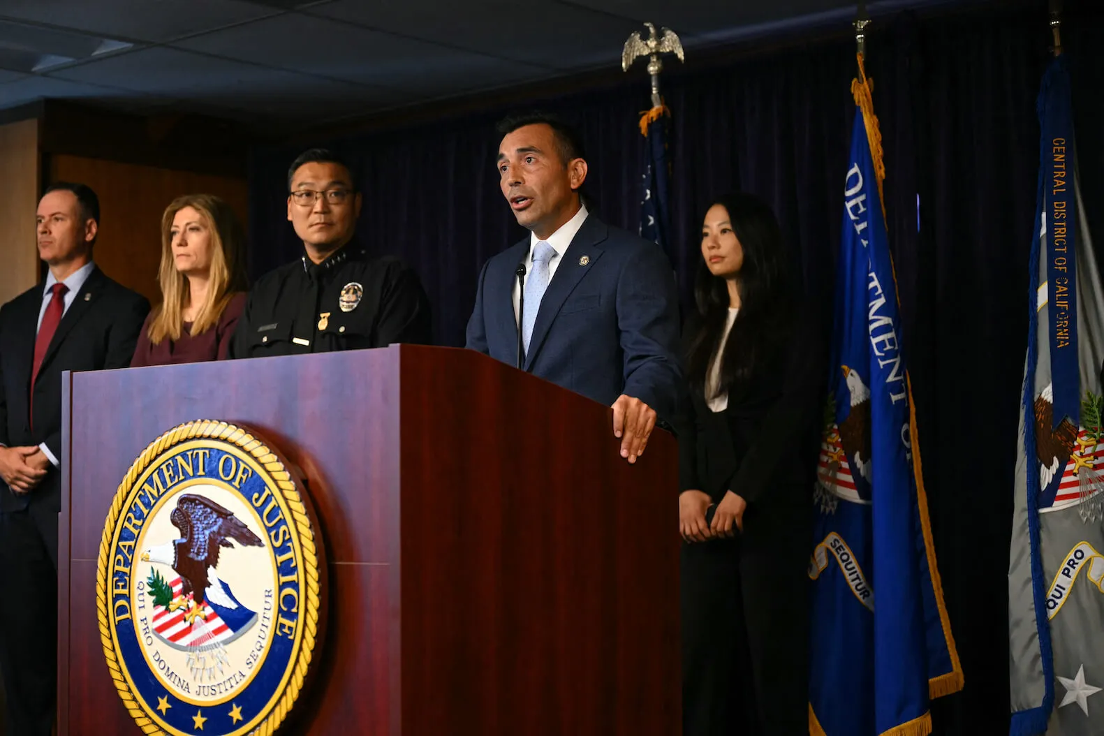 U.S. Attorney for the Central District of California, Martin Estrada, speaks during a press conference on Aug. 15, 2024, announcing arrests in the death of 'Friends' actor Matthew Perry. He stands at a podium surrounded by others.