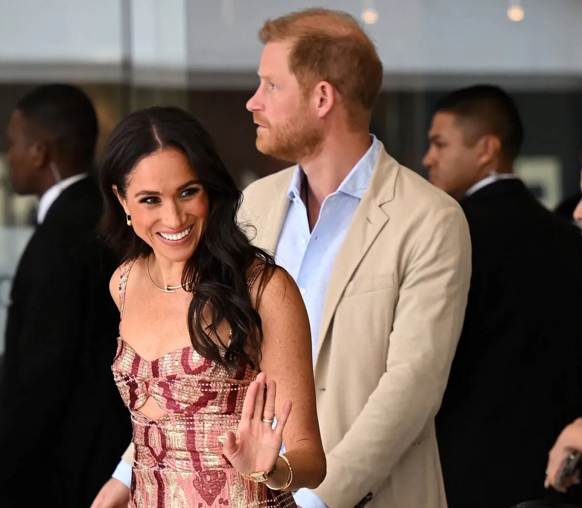 Meghan Markle waves to students as she and Prince Harry arrive for a visit to the National Centre for the Arts in Bogota, Colombia