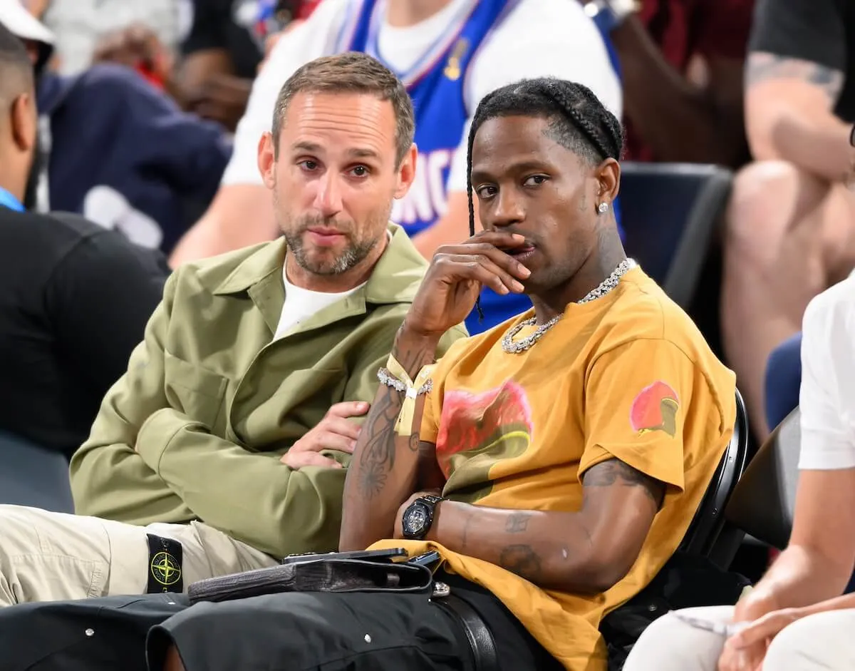 Michael Rubin sits next to Travis Scott as they watch a basketball game at the 2024 Olympics