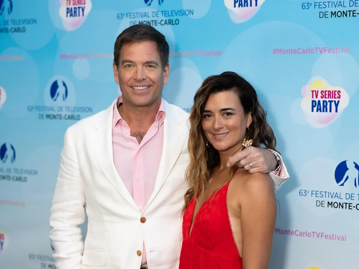 Michael Weatherly in a white suit posing next to Cote de Pablo in a red dress at the Red Carpet during the 63rd Monte-Carlo Television Festival.