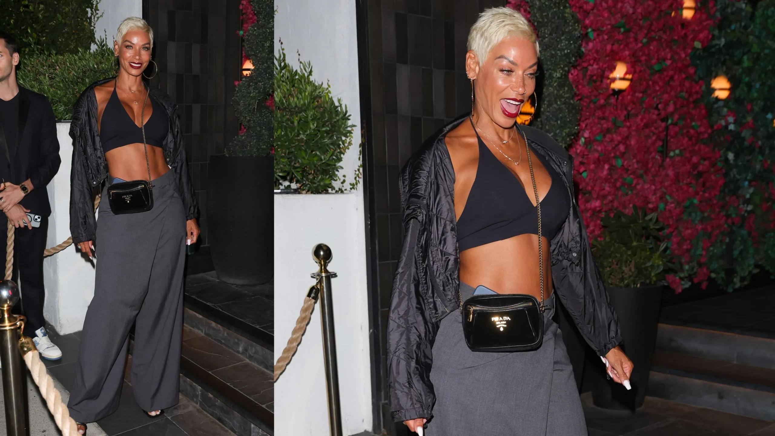 Wearing a black coat and pants, Nicole Murphy smiles for paparazzi outside of a steakhouse in LA